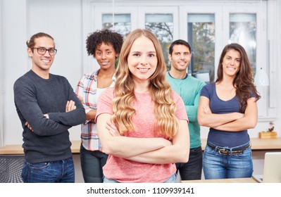 Young woman as apprentice or trainee in internship in front of her business team in the office