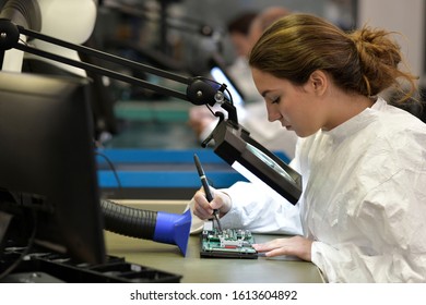 Young woman apprentice working in microelectronics lab