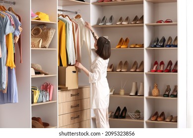 Young woman arranging clothes at wardrobe - Shutterstock ID 2095323856
