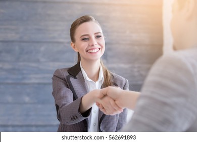 Young Woman Arriving For A Job Interview. Business People Handshake In Modern Office. Greeting Deal Concept