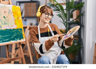 Young woman artist listening to music drawing at art studio - Powered by Shutterstock