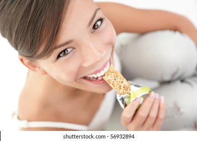 Young Woman Asian Caucasian Eating Healthy Muesli Bar.