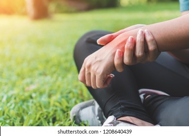 Young Woman Asian Have Accident And Holding Her Wrist Pain Twist Sprain In Sport Exercise Jogging, Selective Focus.