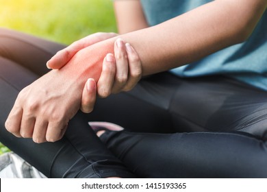 Young Woman Asian Have Accident And Holding Her Wrist Pain Twist Sprain In Sport Exercise Jogging, Selective Focus.