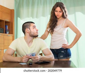 Young Woman Asking For Money From Her Husband For The Purchase 