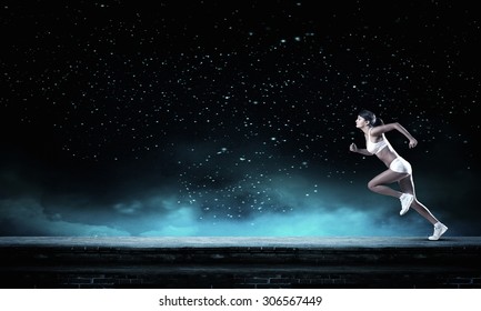 Young Woman Athlete Running Fast On Dark Background 