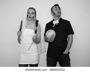 Young Woman And Attractive Man Wearing Halloween Costumes For Party. Celebrating Halloween In 2020 At Home Quarantine. Situation Caused By Coronavirus. Dark Wedding.