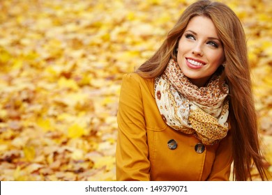 Young Woman With Autumn Leaves In Hand And Fall Yellow Maple Garden Background 