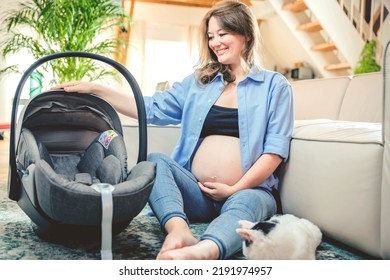 Young Woman With A Baby Car Seat Sitting On The Floor At Home