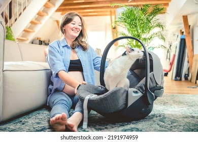 Young Woman With A Baby Car Seat Sitting On The Floor At Home