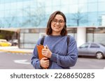 Young woman, with backpack, headphones, ready to start university. Medium shot photography.