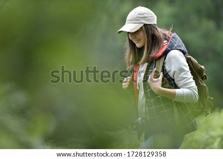 Young woman with backpack hiking in forest