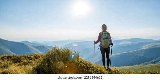 Young woman with backpack hiking in the mountains - Powered by Shutterstock