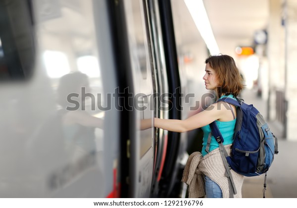 Young woman with backpack take the train.\
Tourism and travelling.