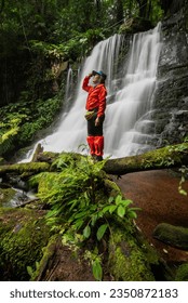 young woman backpacker looking at the waterfall in jungles. Ecotourism concept image travel girl. Traveler Vacations Concept