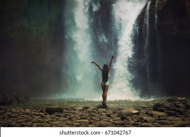 young woman backpacker looking at the waterfall in jungles. Ecotourism concept image travel girl