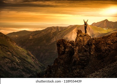 Young Woman Backpacker In Victory Pose With Raised Up Arms On Top Of The Mountain Colorado USA