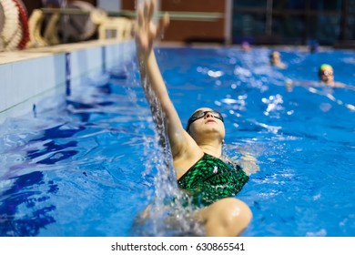 Young Woman Backstroke Swimming In Closed Pool 