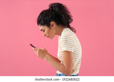 Young woman with bad posture using mobile phone on color background - Shutterstock ID 1922683022