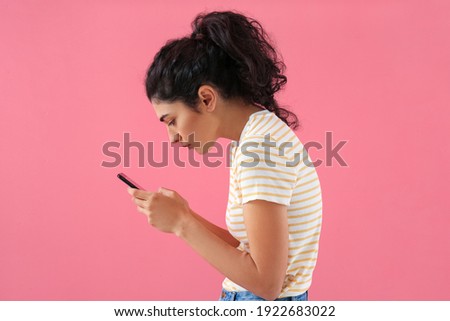 Young woman with bad posture using mobile phone on color background