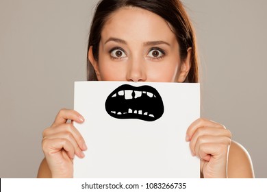 Young Woman With Bad Teeth Drawn On Paper On Gray Background