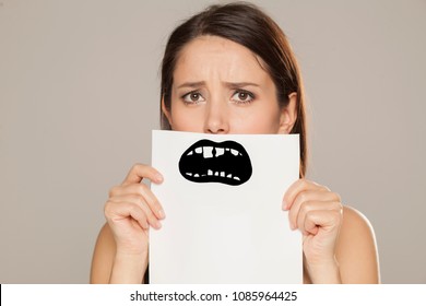 Young Woman With Bad Teeth Drawn On Paper On Gray Background