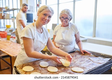 Young Woman Baker Apprentice In Apprenticeship Baking With Instruction In Bakery