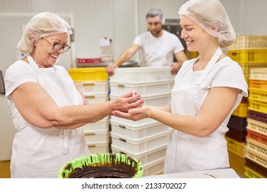 Young Woman Baker Apprentice Bakes Chocolate Biscuits Under Supervision In Family Bakery