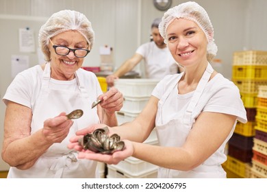 Young Woman Baker Apprentice And Older Baker With Madeleine Biscuit Molds For Baking