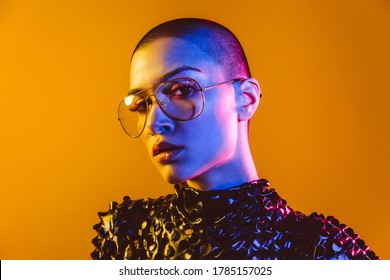 Young Woman With Bald Head Dancing And Having Fun. Gel Colored Portrait