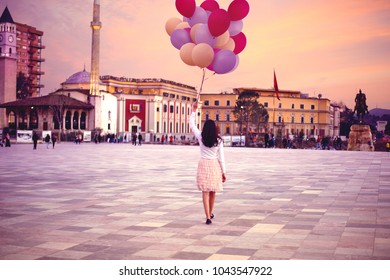 Young Woman With A Lot Of Balloons Walking In Tirana Central Square In Evening Dreamy Scenic Sunset