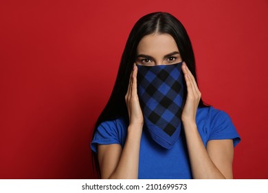 Young Woman With Bandana Covering Her Face On Red Background, Space For Text