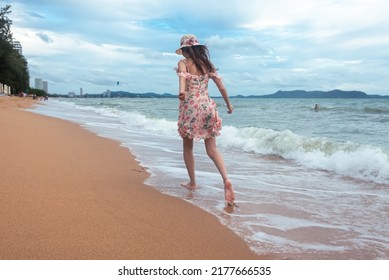 Young Woman Barefoot Walking On The Sand Beach.
