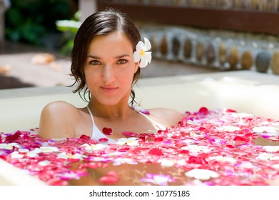 A Young Woman In A Bath With Petals And Flowers