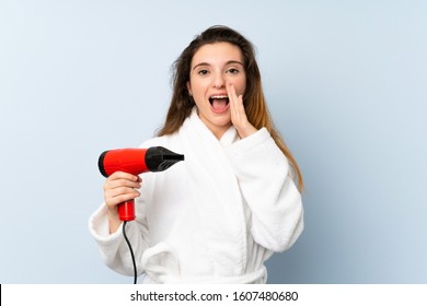 Young Woman In A Bathrobe With Hair Hairdryer Shouting With Mouth Wide Open