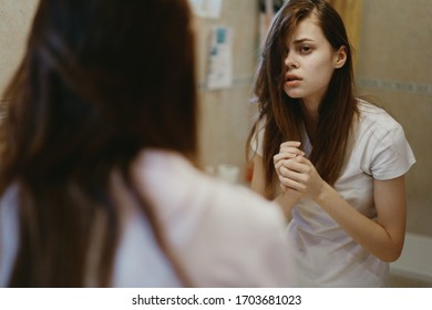 young woman in the bathroom in a white t-shirt - Shutterstock ID 1703681023