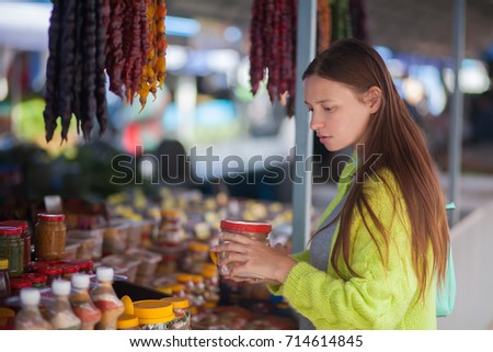 Young woman at the bazaar, buying food ingredients