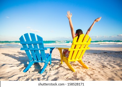 Young Woman In Beach Chair Raised Her Hands Up