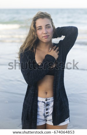 Young woman sits at the Baltic Sea beach