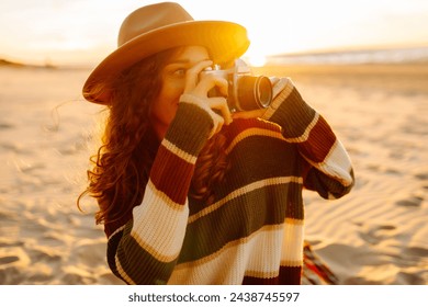 Young Woman at the Beach with Vintage Camera. Picnic, relax, weekend. - Powered by Shutterstock