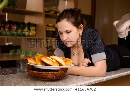 young woman with beautiful breasts on the bar with pies in the restaurant