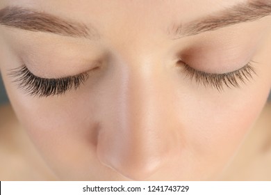 Young woman with beautiful eyelashes, closeup. Before and after extension procedure