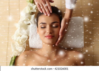 Young woman in beauty spa salon enjoying head massage with snow effect