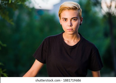 Young Woman Beauty Tomboy Lifestyle With Blonde Short Hair Posing In Casual Clothes In A Park In Spain.
Jeans And T-shirt Showing Armes, Gender Education And Non Binary Teen.