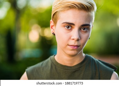 Young woman beauty Tomboy lifestyle with blonde short hair posing in casual clothes in a park in Spain.
Jeans and t-shirt showing armes, gender education and non binary teen. - Shutterstock ID 1881719773
