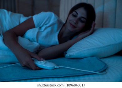 Young Woman In Bed With Electric Heating Pad, Focus On Cable