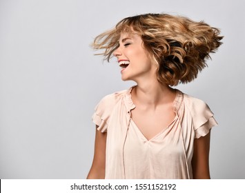 Young Woman In A Beige Short-sleeved Satin Blouse Shakes Her Head With Her Hair. The Concept Of Joy, Happiness, Joy, Fun