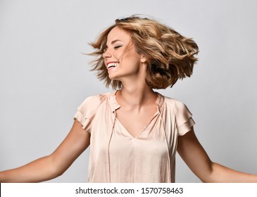 Young Woman In A Beige Short-sleeved Satin Blouse Shakes Her Head With Her Hair. The Concept Of Joy, Happiness, Joy, Fun