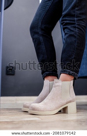 Young woman in beige stylish fashionable leather lace-up shoes. Fashionable collection of women's autumn shoes. Close-up of female legs in shoes.