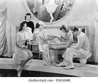 Young Woman Being Pampered By Three Women And A Man